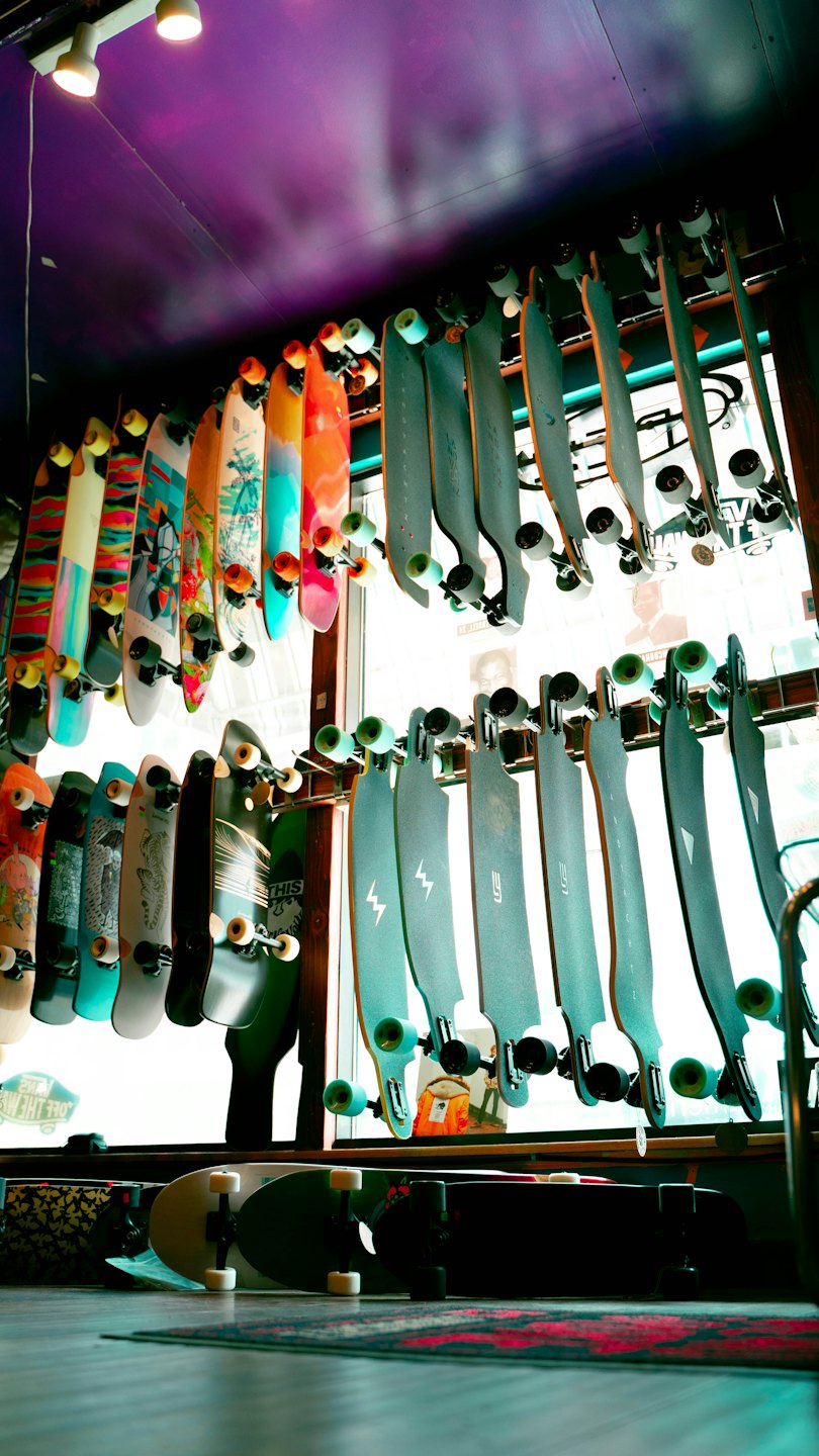 Skateboards and longboards displayed on racks in a shop.